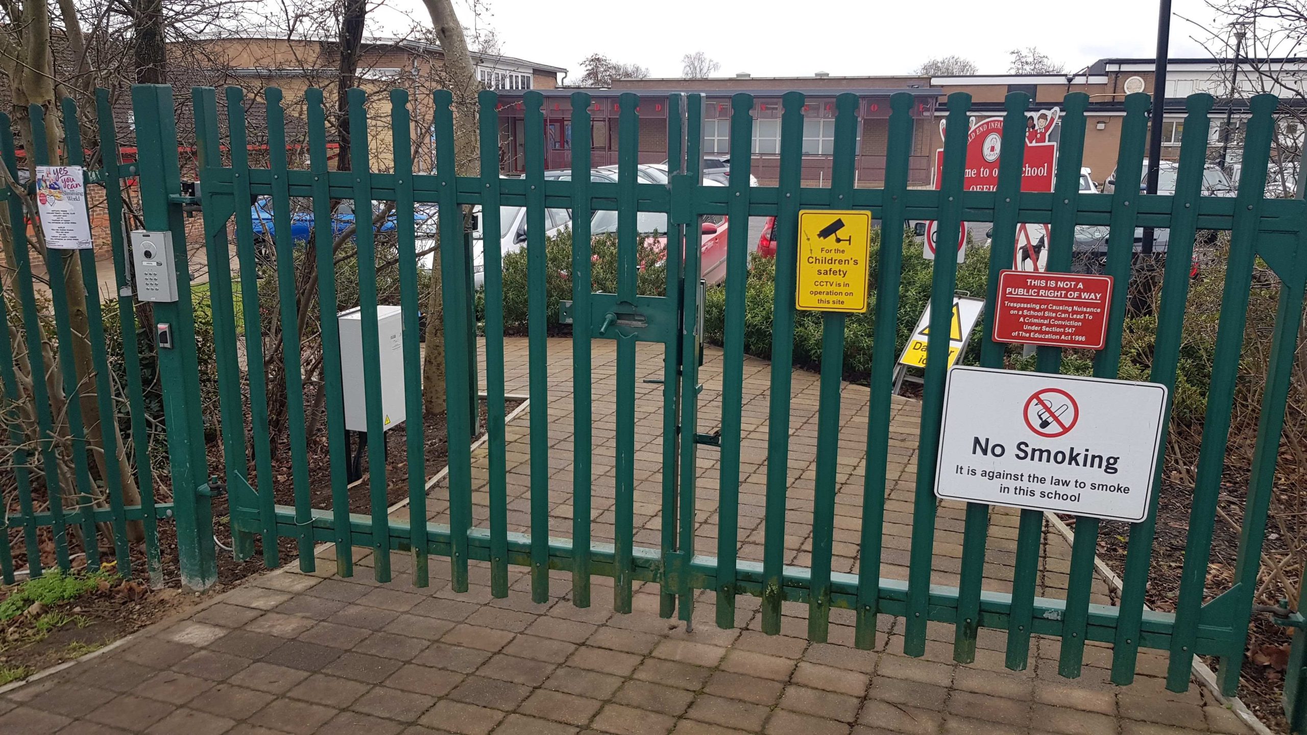 School gate with CCTV sign on it